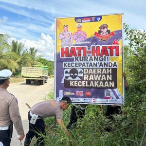 MELAKUKAN PEMANTAUAN ARUS LALU LINTAS, UNIT TURJAWALI SATLANTAS POLRES KUTIM MEMASANG SPANDUK DITITIK RAWAN KECELAKAAN